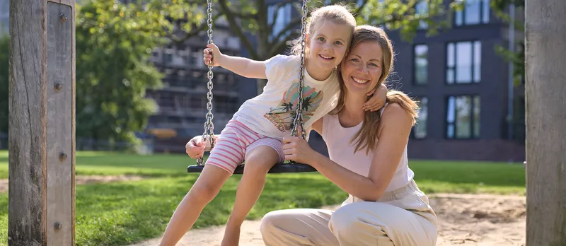 Eine Frau mit ihrer Tochter auf dem Spielplatz.