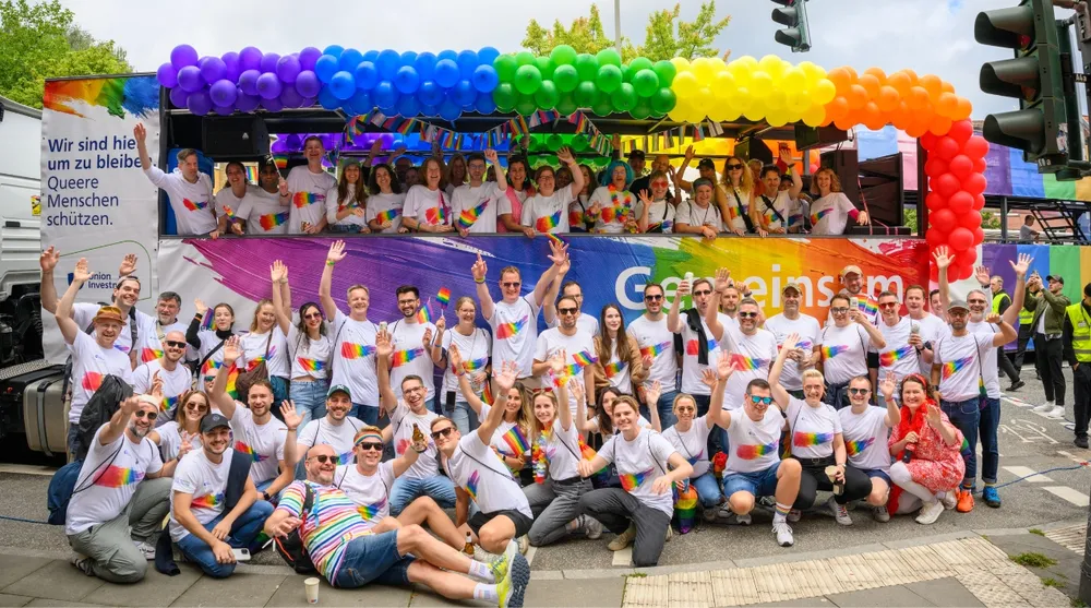 Eine Gruppe von Menschen vor einem buntem Truck auf dem Christopher Street Day in Hamburg. 