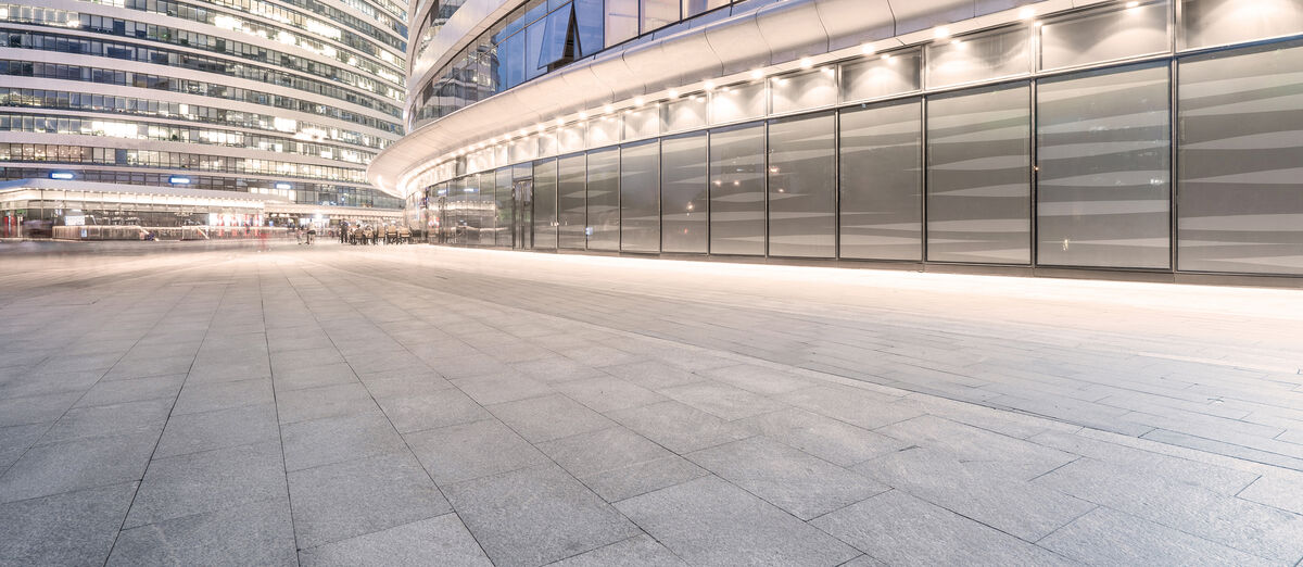 Modern glass façade with illuminated forecourt at night Modern glass façade with illuminated forecourt at night