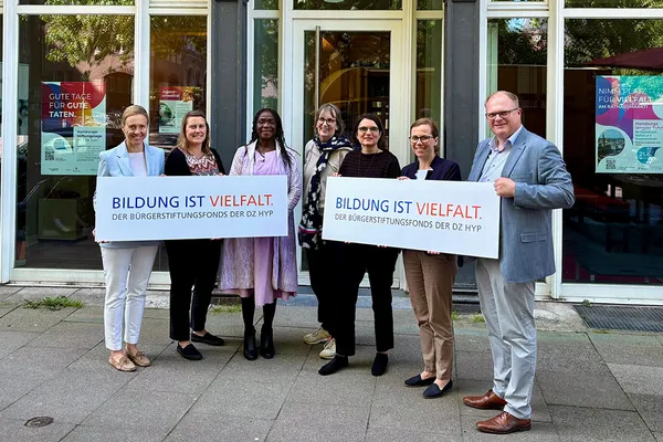 Übergabe des DZ HYP Bürgerstiftungsfonds Mehrere Menschen vor einigem Gebäude mit Schildern in der Hand