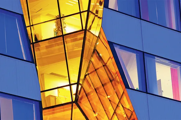 Ausschnitt Titelbild Halbjahresbericht 2026, Fassade orange beleuchtet Ausschnitt Titelbild Halbjahresbericht 2026, Fassade orange beleuchtet