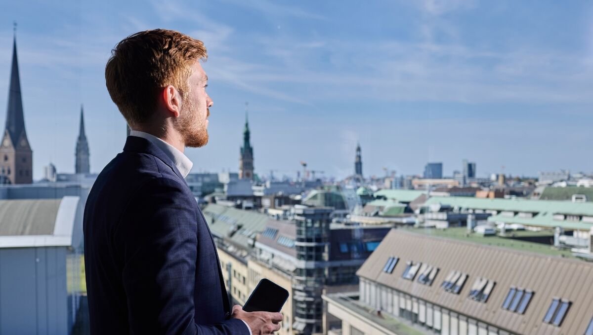 Ein Trainee schaut aus dem Fenster und überblickt die Stadt.